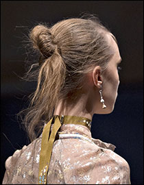 Ce que c’est : Dites bonjour à votre nouvelle coiffure favorite, le nœud parfaitement imparfait, rapide et facile à exécuter. Aperçu sur les passerelles d’Etro, de Vivienne Westwood et de Bottega Veneta, il a juste ce qu’il faut d’audace et de caractère.  Le mode d’emploi : Une fois les cheveux lavés et essorés à la serviette, on les sèche au séchoir, à la va-vite. Puis, on démêle les mèches délicatement à l’aide d’une brosse antifrisottis afin d’éliminer la statique et de rendre la chevelure douce au toucher. On attache ensuite un élastique autour des longueurs puis on forme un « nœud » volontairement déglingué.  Notre suggestion: La Brosse Parfaite Infiniti Pro, de Conair